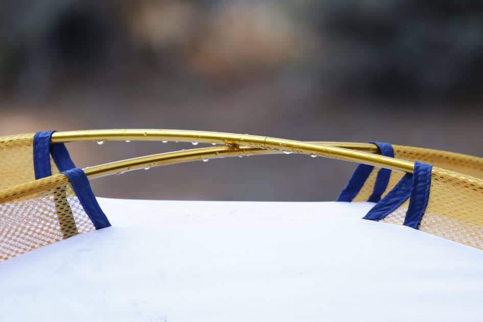Close-up of tent poles with raindrops, highlighting the importance of strong poles and proper weatherproofing for stability.