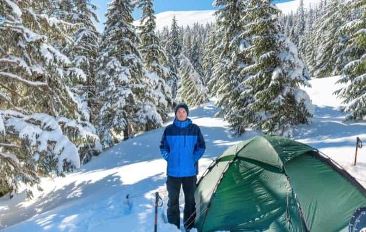 3 or 4 season tent , man in blue jacket on snowy ground
