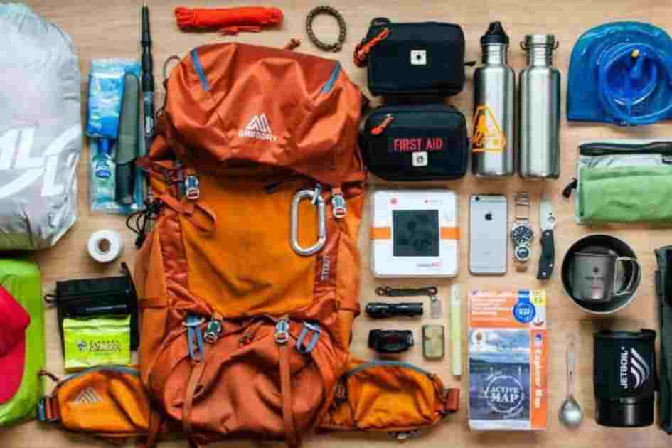 A flat lay of ethically-produced hiking gear essentials, including a backpack, water bottles, first aid kit, and sustainable gear.