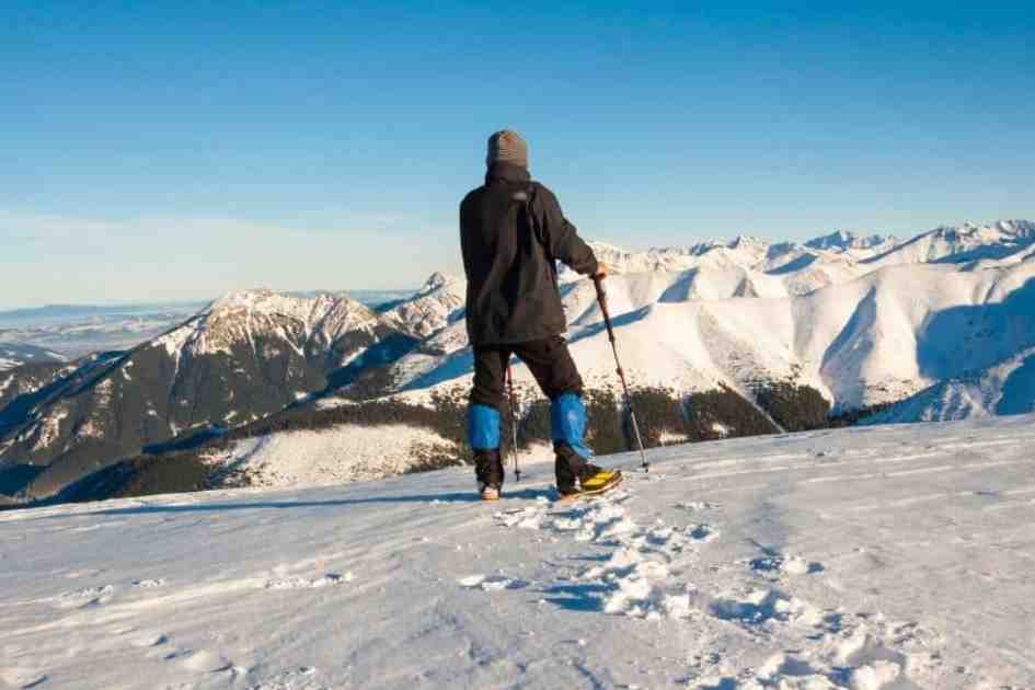 Hiker using trekking poles on a snowy mountain trail
