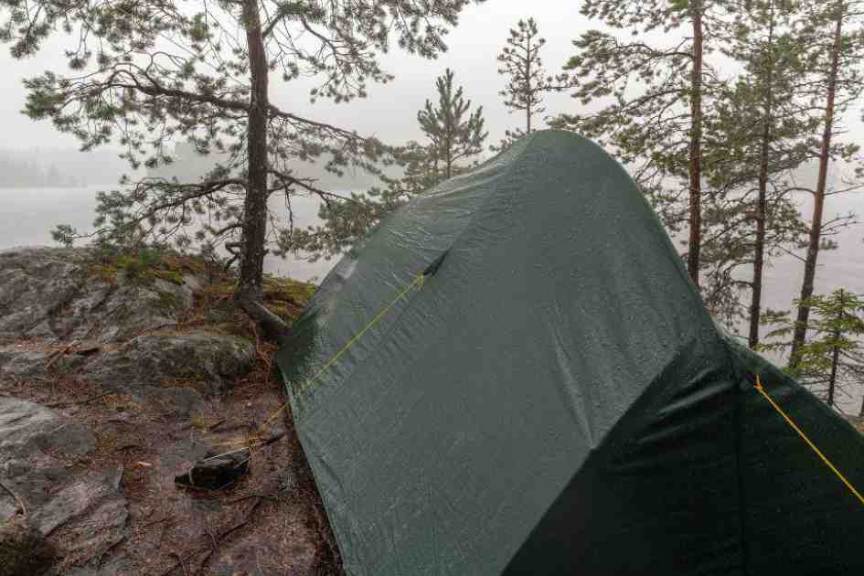 A tent pitched in rainy weather, showing how essential it is to properly weatherproof a tent for wet conditions.